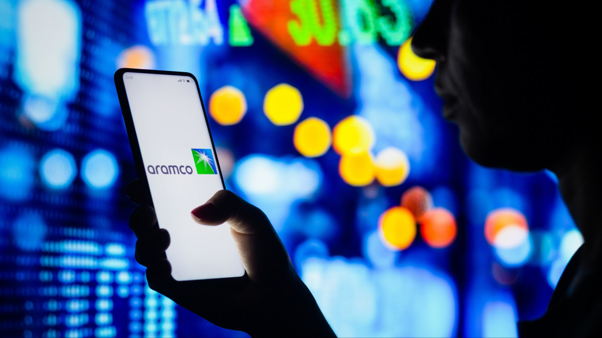 BRAZIL - 2022/04/04: In this photo illustration, a womans silhouette holds a smartphone with the Saudi Arabian Oil Company (Aramco) logo displayed on the screen. (Photo Illustration by Rafael Henrique/SOPA Images/LightRocket via Getty Images)