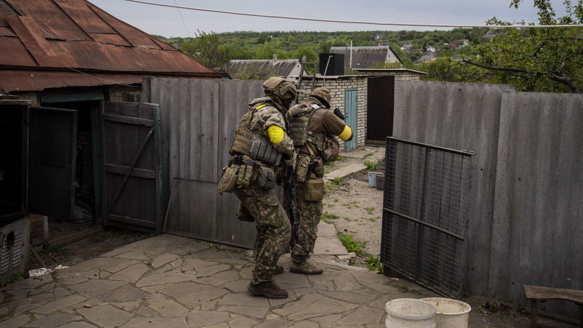 Ukrán katonák egy felderítő küldetés közben az ukrán hadsereg által visszafoglalt települések egyikén, a kelet-ukrajnai Harkiv közelében 2022. május 14-én.
