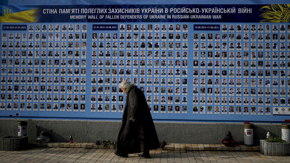 A kelet-ukrajnai háború áldozatainak emlékfala előtt megy el egy nő Kijevben 2022. május 23-án. A fegyveres konfliktus 2014 márciusában robbant ki a az oroszbarát szakadárok és az ukrán hadsereg között a Donyeck és Luhanszk megyék feletti fennhatóságért.