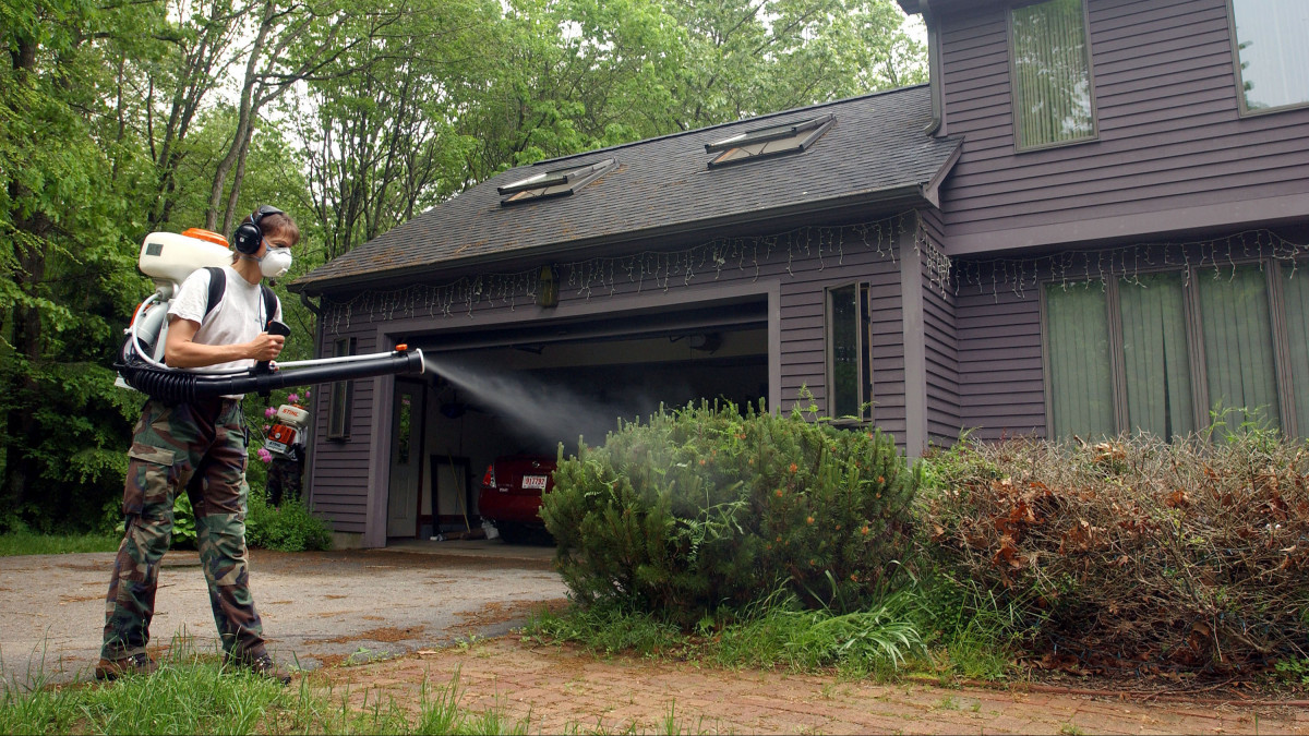 STRATHAM, NH - JUNE 9:  Dragon Mosquito Control employee Diana Eddins-Wiggin sprays a home to help keep down the mosquito population June 9, 2005 in Stratham, New Hampshire. As the wet spring weather moves into the heat of summer, experts expect a mosquito explosion, some of which carry the West Nile Virus and Eastern Equine Encephalitis (EEE). Last year EEE killed three people in the state of Massachusetts.  (Photo by Darren McCollester/Getty Images)