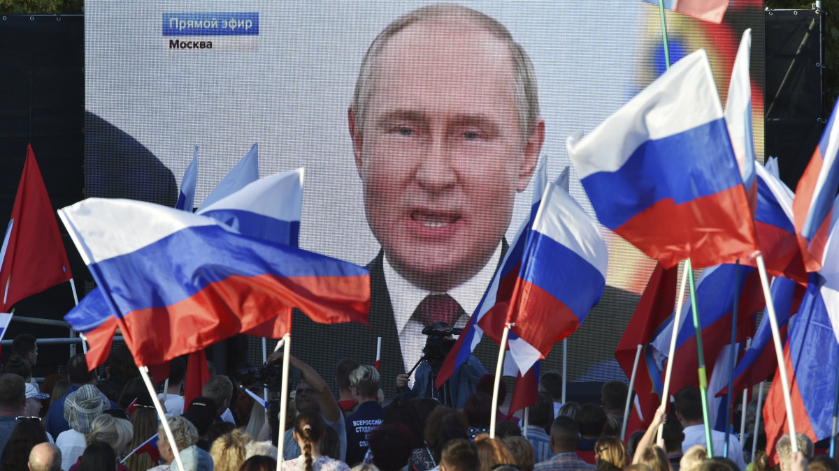 Orosz zászlókat lengető emberek ünnepelnek Moszkvában 2022. szeptember 30-án, miután Vlagyimir Putyin orosz elnök bejelentette a négy kelet-ukrajnai régió Oroszországhoz csatolását. Putyin a szakadár Donyecki és Luhanszki Népköztársaság, valamint Herszon és Zaporizzsja megye vezetőivel írta alá a csatlakozásról szóló egyezményt.