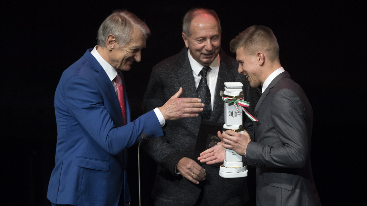 Sigér Dávid, a Ferencvárosi labdarúgója (j) átveszi az év góljáért járó elismerést Fazekas László olimpiai bajnok, ezüstcipős, 92-szeres válogatott labdarúgótól (j2) és Dunai Antal olimpiai bajnok, ezüstcipős válogatott labdarúgótól az M4 Sport - Év sportolója gálán a Nemzeti Színházban 2019. február 14-én.