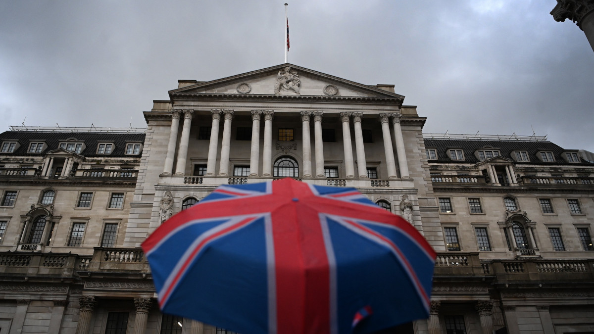 A brit jegybank, a Bank of England londoni épülete előtt egy esernyős járókelő 2022. november 3-án. A monetáris tanács háromnegyed százalékponttal 3 százalékra emelte az alapkamatát, ami az utóbbi több mint 30 évben a brit jegybank legnagyobb kamatlábemelése.