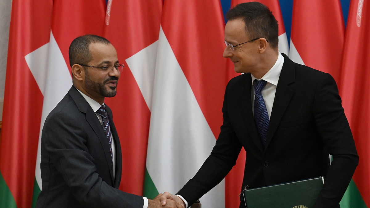 Badr bin Hamad bin Hamud al Buszaidi ománi külügyminiszter (b) és Szijjártó Péter külgazdasági és külügyminiszter kezet fog, miután együttműködési megállapodást írt alá Budapesten, a minisztériumban 2022. december 15-én.