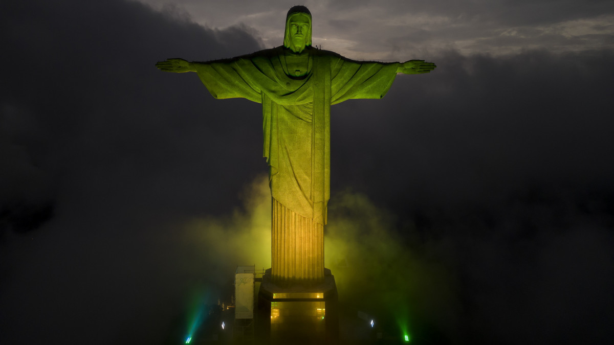 Pelé tiszteletére a brazil zászló színei világítják meg a Megváltó Krisztus-szobrot Rio de Janeiróban 2022. december 29-én, az egykori brazil futballcsillag halálának napján. Edson Arantes do Nascimento, közismert nevén Pelé 82 évesen hunyt el daganatos betegségben Sao Paulóban. Jair Bolsonaro brazil elnök háromnapos nemzeti gyászt rendelt el a háromszoros világbajnok tiszteletére.