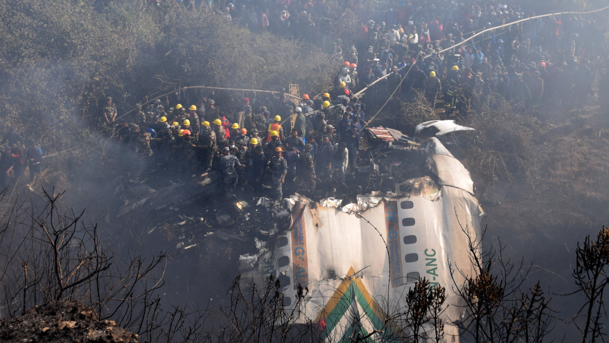 A roncsok mellett mentők 2023. január 15-én, miután lezuhant a Yeti Airways nepáli légitársaság belföldi járaton közlekedő utasszállító repülőgépe Pokharában, a repülőtér közelében. A fedélzeten tartózkodó 72 ember közül legalább 67 életét vesztette.