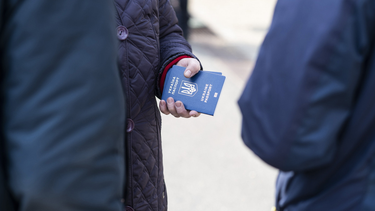Az orosz-ukrán háború elől Ukrajnából menekülő ember tartja kezében útlevelét a záhonyi vasútállomáson 2022. március 7-én.