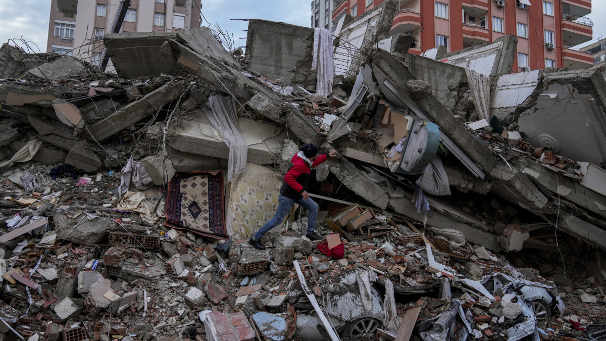 Férfi egy összedőlt épület törmelékhalmán a dél-törökországi Adana nagyvárosban 2023. február 6-án. Hajnalban több erős földrengés rázta meg Törökország délkeleti és Szíria északi részét, a legnagyobb rengés egyes mérések szerint a 7,8-as erősséget is elérte. A földmozgásnak Törökországban és Szíriában is több száz halálos áldozata és több ezer sérülje van.