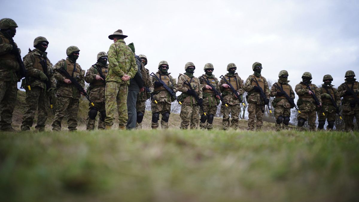 Ausztrál katona ukrán katonákhoz beszél az angliai Wiltshire grófságban elterülő Salisbury-síkságon, ahol az ausztrál hadsereg segít a brit fegyveres erőknek az ukrán katonák kiképzésében 2023. február 1-jén, az Ukrajna elleni orosz háború alatt.