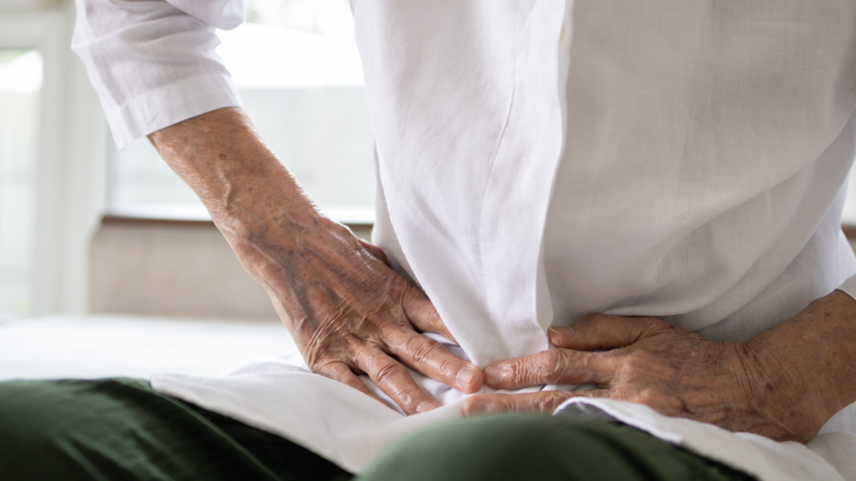 Sick senior patient having aching belly,hands hold stomach,stomachache,old people with symptoms gastrointestinal system disease,crampy abdominal pain hurt in stomach caused by indigestion or diarrhoea