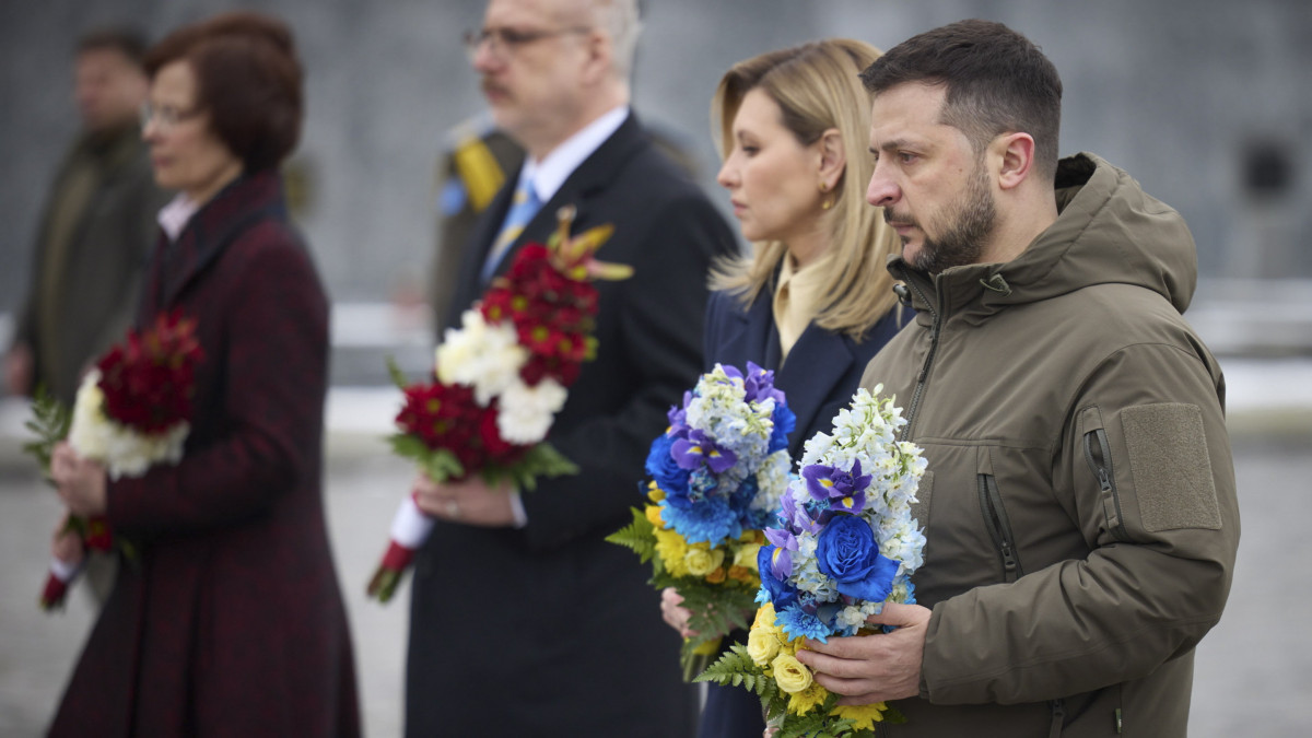 Az ukrán elnöki hivatal sajtóosztályának felvételén Volodimir Zelenszkij ukrán elnök (j) és felesége, Olena Zelenszka, valamint Egils Levits lett államfő (b2) és felesége, Andra Levite (b) lerója kegyeletét az egy éve tartó ukrajnai háborúban elesett ukrán katonák emléke előtt a nyugat-ukrajnai Lemberg katonai temetőjében 2023. március 3-án, az orosz erők ukrajnai ostromának idején.