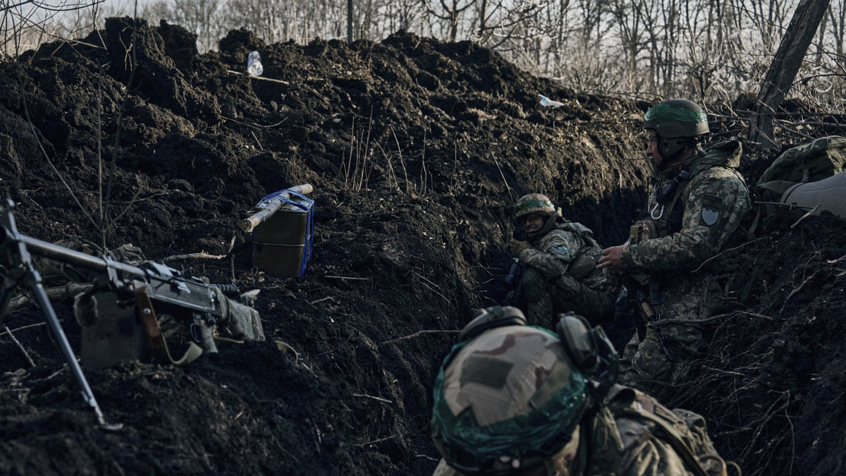 Ukrán katonák egy lövészárokban a donyecki régióban fekvő, ostromgyűrűben lévő Bahmutban 2023. március 5-én. Bahmutot az ukrán védelmi erők tartják ellenőrzésük alatt, míg az orosz egységek erőiket a környező települések irányában történő támadó műveletek végrehajtására összpontosítják.