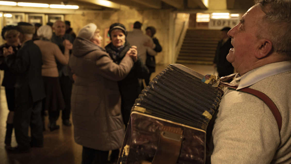 Idős párok élő zenére táncolnak a kijevi Teatralna metróállomás aluljárójában 2023. március 5-én, az Ukrajna elleni orosz hadviselés idején. A mintegy kétórás összejövetelen több tucat nyugdíjas korú ember vett részt, akik elmondása szerint az állomáson évtizedek óta rendszeresen tartanak közös táncot, amely az orosz invázió miatt átmenetileg szünetelt.