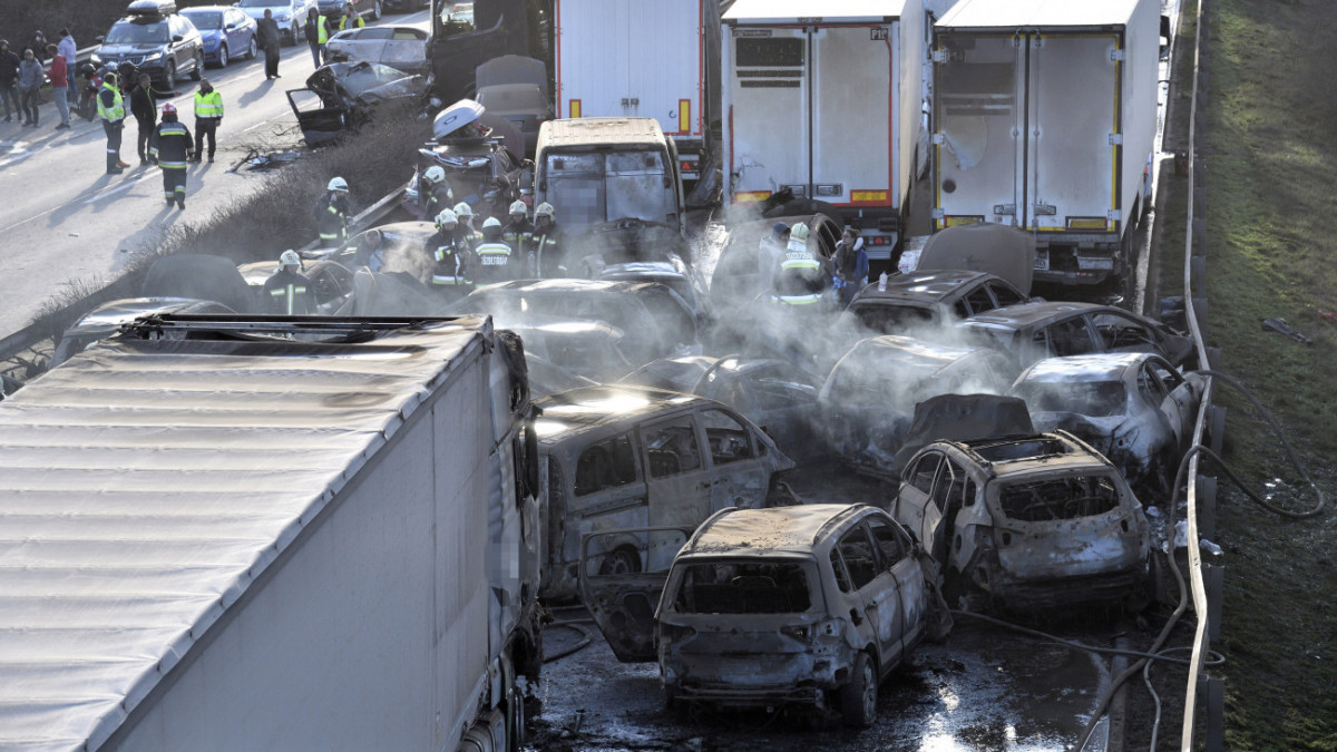 Herceghalom, 2023. március 11. Kiégett és sérült gépjárművek az M1-es autópályán Herceghalomnál, ahol öt kamion és 37 autó ütközött össze, mindkét irányban lezárták az autópályát 2023. március 11-én. A balesetben érintett öt kamion és 37 személygépkocsi közül 19 jármű kiégett, és összesen 26 ember sérült meg. Közülük hatan életveszélyesen, heten pedig súlyosan sérültek.MTI/Lakatos Péter