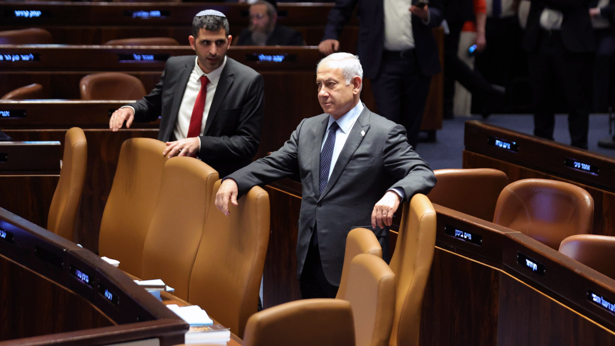 Benjámin Netanjahu izraeli miniszterelnök (k) a jeruzsálemi parlament ülésén 2023. március 27-én, amikor folytatódnak a tömeges tiltakozások a kormány igazságügyi reformterve ellen. Bírálói szerint a reformtervezet megnyirbálná az alkotmánybíróságként is működő izraeli legfelsőbb bíróság jogköreit. Netanjahu ezzel szemben azt állítja, hogy a módosításoknak köszönhetően helyreállna a hatalmi ágak egyensúlya, amely jelenleg az igazságszolgáltatás irányába billen el.