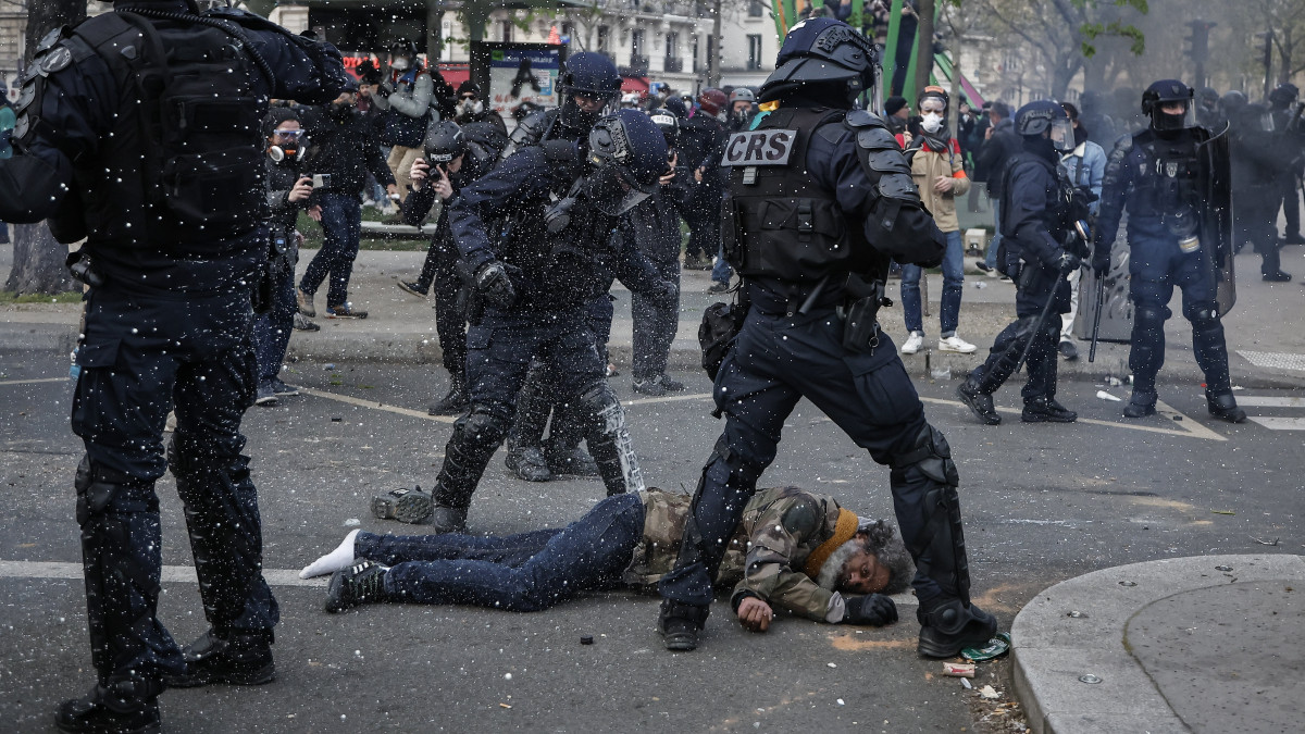 Földön fekvő férfi a nyugdíjreform ellen tüntetők és rohamrendőrök összecsapása közben Párizsban 2023. március 28-án. Emmanuel Macron francia elnök széles körű felháborodást váltott ki azzal, hogy parlamenti szavazás nélkül készül hatályba léptetni a nyugdíjkorhatár 62-ről 64 évre emelését előirányzó törvényt.