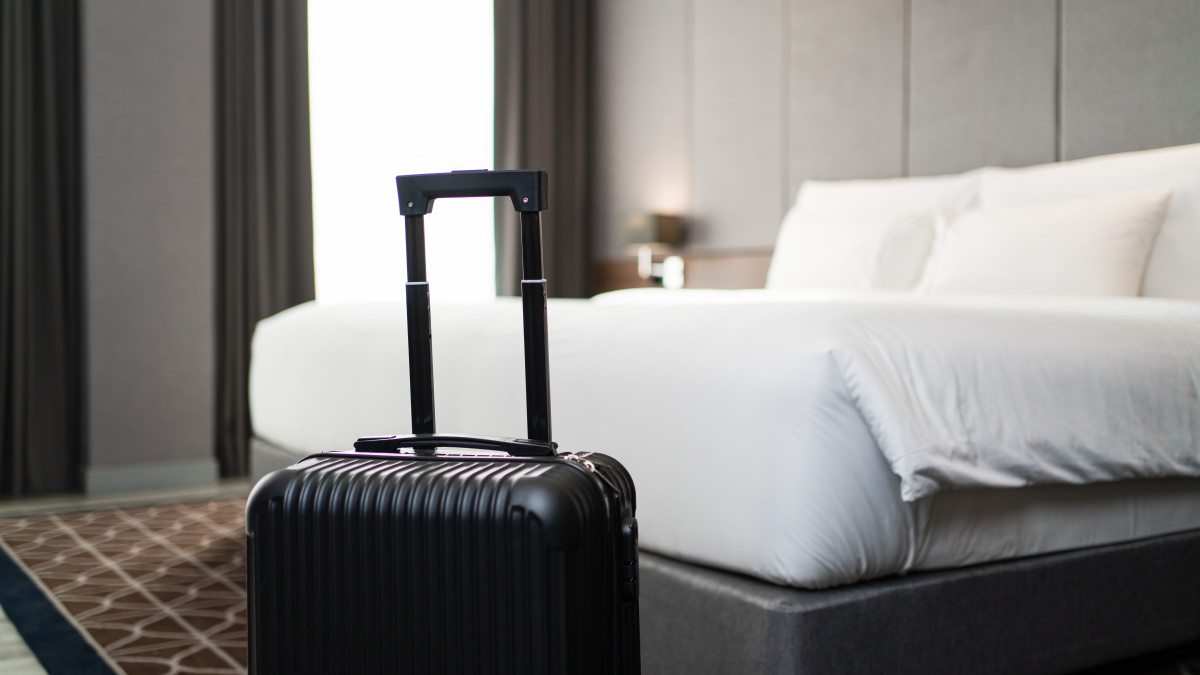 A suitcase placing in front of the bedroom in luxury hotel room