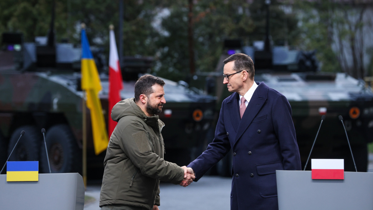 Volodimir Zelenszkij ukrán államfő (b) és Mateusz Morawiecki lengyel miniszterelnök kezet fog a kancellária varsói épülete előtt tartott sajtótájékoztatójuk végén 2023. április 5-én. Zelenszkij az ukrajnai háború egy évvel ezelőtti kezdete óta először tartózkodik hivatalos látogatáson Lengyelországban.