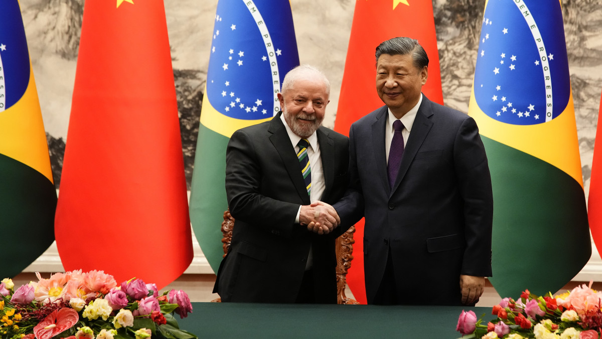 A hivatalos látogatáson Kínában tartózkodó Luiz Inacio Lula da Silva brazil elnök (b) és Hszi Csin-ping kínai államfő kezet fog, miután megállapodást írtak alá a pekingi Nagy Népi Csarnokban 2023. április 14-én.