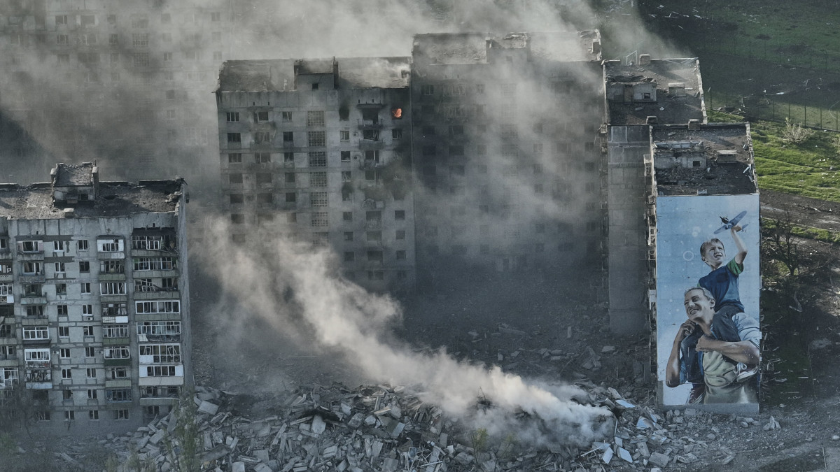 Találatot kapott lakóház füstöl az orosz erők által ostromlott kelet-ukrajnai Bahmutban 2023. április 26-án.