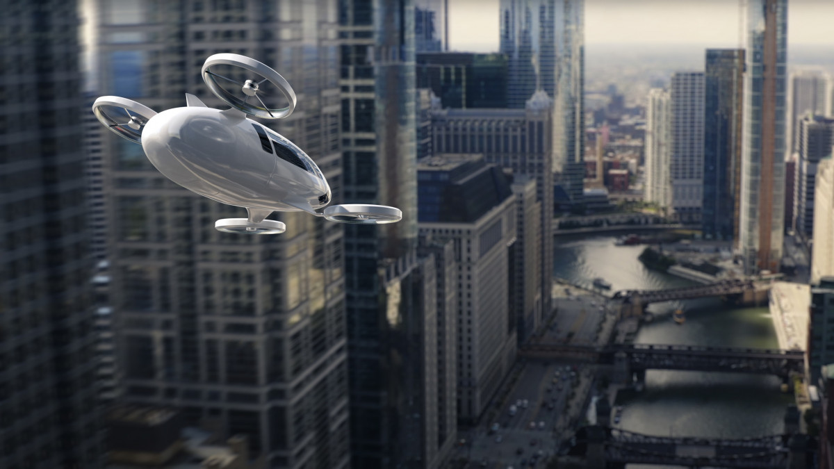 A generic electric vertical take off and landing aircraft flying high off the ground through high rise buildings through a modern urban downtown cityscape. The white eVTOL has two front and two rear rotors and is flying at speed above a river.