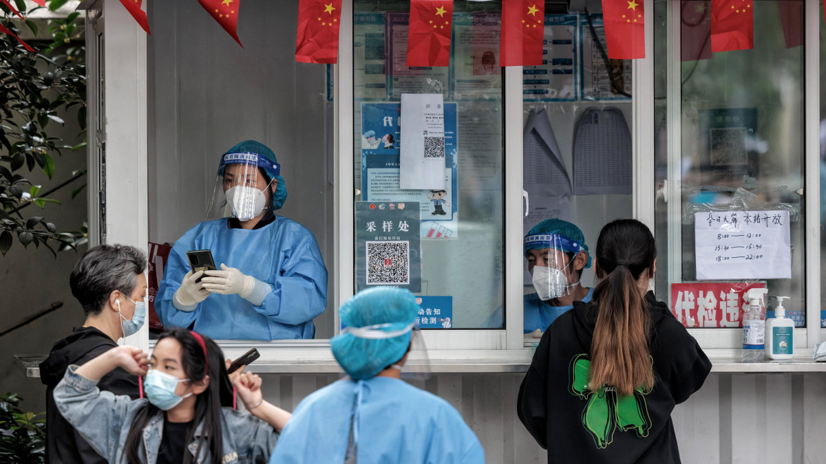 Koronavírus-tesztre várakoznak emberek Sanghajban 2022. október 16-án. A 25 millió lakosú város vezetése a koronavírusos megbetegedések folyamatosan növekvő száma miatt ismét vesztegzár alá helyezi az érintett városrészeket, más városok kijárási és utazási korlátozásokat vezettek be.