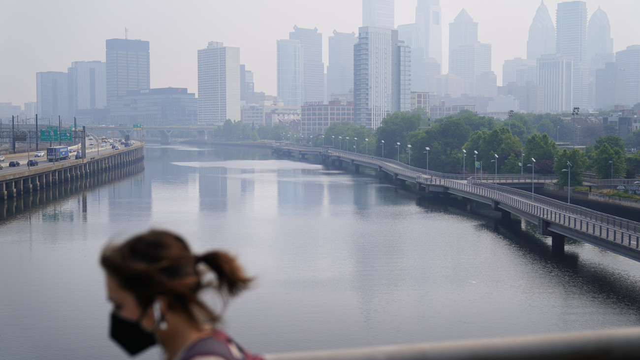 A füstfelhő miatt védőmaszkot viselő járókelő a Pennsylvania állambeli Philadelphiában 2023. június 8-án. A kanadai erdőtüzek füstje miatt az Egyesült Államok több északkeleti államában levegőminőségi riasztás van érvényben.
