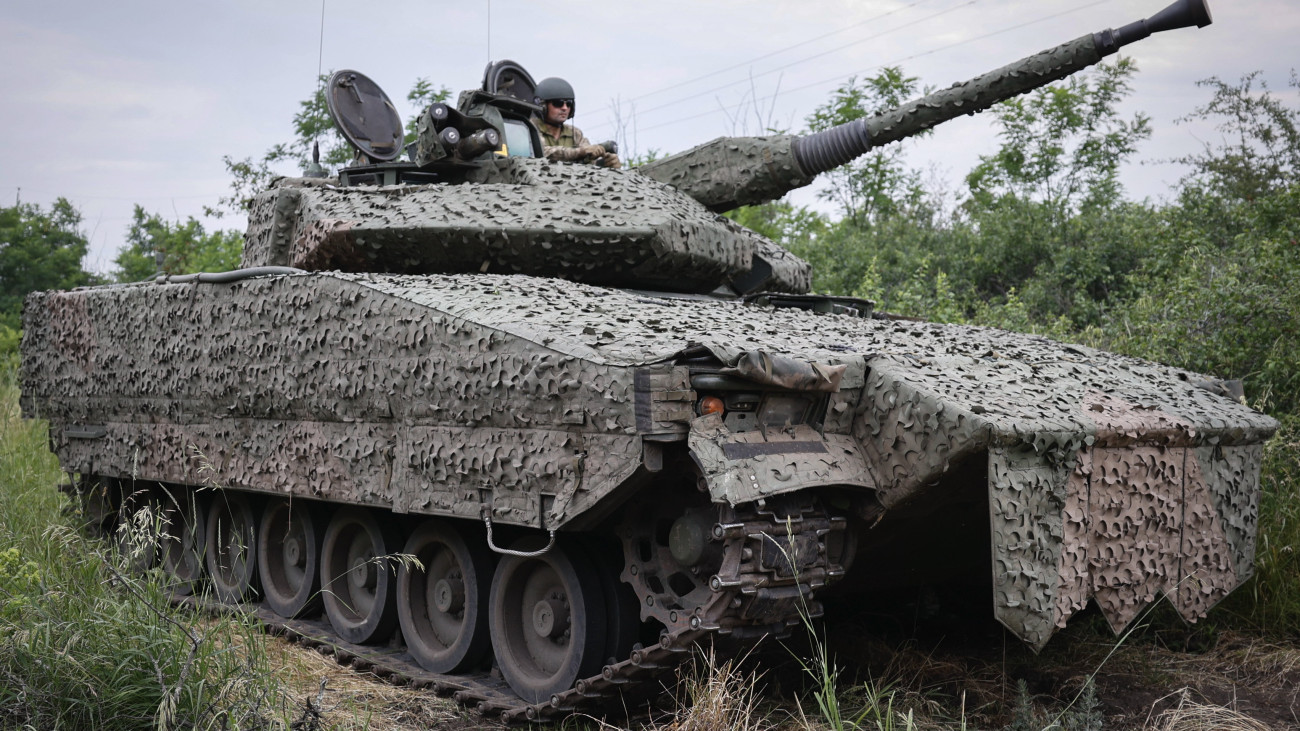 Ukrán katona egy álcázott, svéd CV90-es gyalogsági harcjárművön a Donyecki területen fekvő kelet-ukrajnai Bahmut közelében 2023. június 26-án.