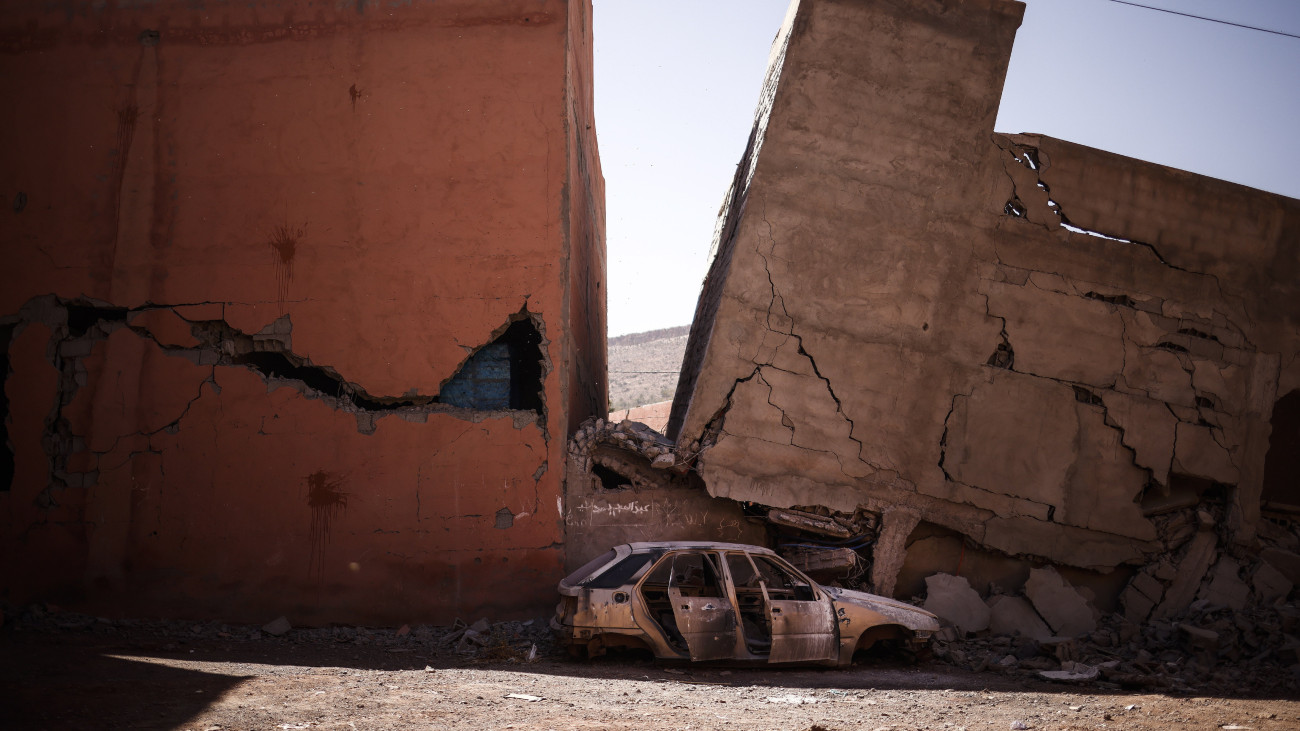 Autó roncsa megsemmisült épületek romjai előtt a földrengés sújtotta marokkói Aszni településen, Marrákestől délre 2023. szeptember 11-én. A szeptember 9-re virradó éjjelen pusztító, 7-es erősségű földmozgás fészkét Marrákestől mintegy 70 kilométerre, délnyugatra mérték. A halálos áldozatok száma 2700 fölé emelkedett, a sebesülteké mintegy 2500-ra.