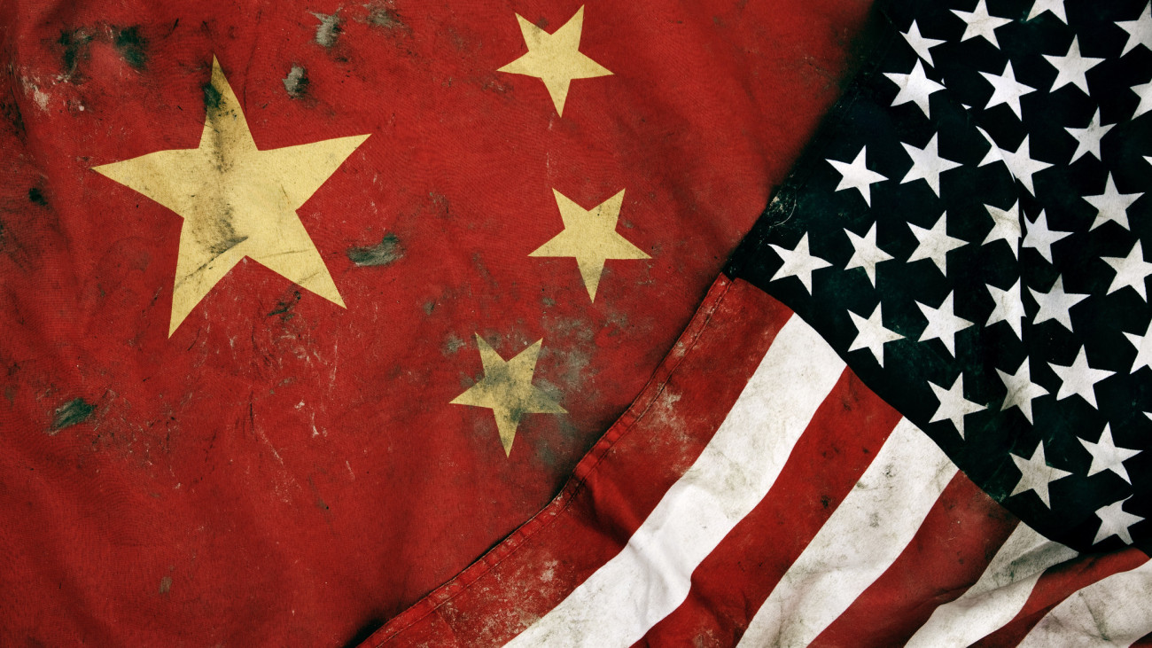 Low key photography of grungy old flags of China and USA.