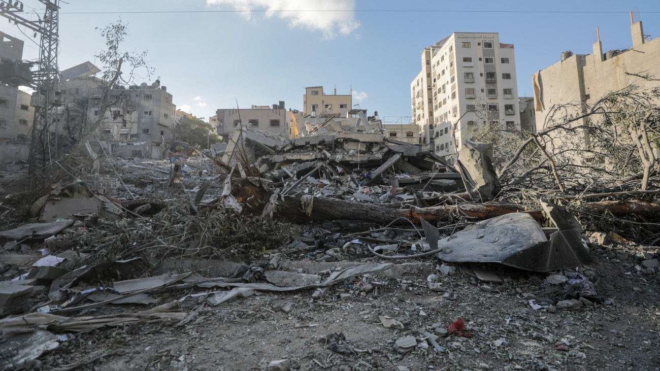 Izraeli légitámadásban összedőlt épület romjai között egy palesztin férfi Gázában 2023. október 15-én. A Gázai övezetet irányító Hamász palesztin iszlamista szervezet október 7-én többfrontos támadást indított Izrael ellen, ahol több mint 1300 ember életét vesztette. A Hamász elleni izraeli válaszcsapások több mint 2300 palesztin halálát okozták a Gázai övezetben.