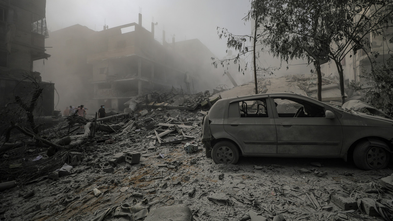 Megrongálódott gépjármű egy összeomlott lakóház romjai mellett Gázában 2023. október 23-án, miután Izrael további légicsapásokat hajtott végre a Hamász iszlamista terrorszervezet gázai infrastruktúrája ellen. A Gázai övezetet irányító Hamász október 7-én többfrontos támadást indított Izrael ellen, ahol meggyilkoltak több mint 1400 embert, háromezret megsebesítettek, körülbelül 200 embert elraboltak és túszként tartanak fogva. A gázai egészségügyi minisztérium közlése szerint a Hamász elleni izraeli válaszcsapások palesztin halálos áldozatainak száma 4651-re emelkedett, a sebesülteké pedig meghaladja a 14 ezret a Gázai övezetben.