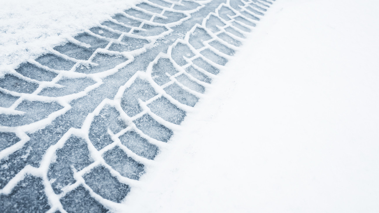 Car track on a wet snowy road, closeup background photo texture