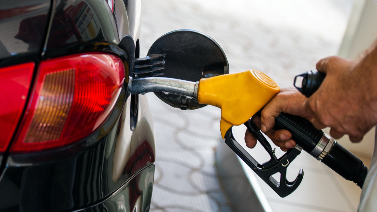 Pumping gas at gas pump. Closeup of man pumping gasoline fuel in car at gas station. Mans hand refueling car at gas station