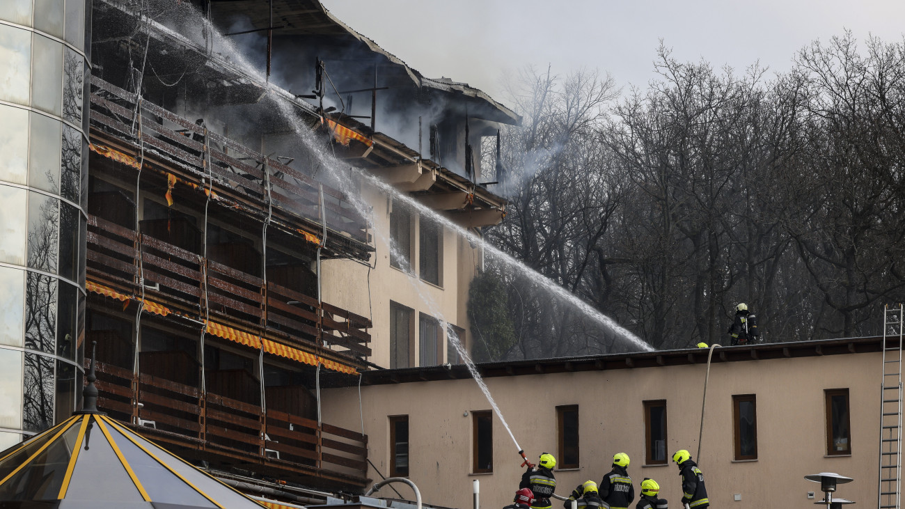 Tűzoltók oltják a kigyulladt visegrádi Hotel Silvanus épületét 2024. március 9-én. A hotel felső szintje teljes terjedelmében kiégett, a vendégek elhagyták az épületet.