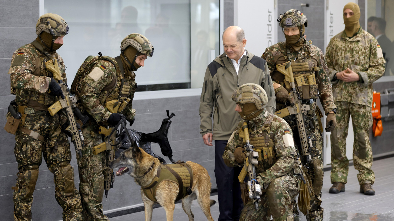 Olaf Scholz német kancellár (k) kommandósok között egy kutyával végrehajtott gyakorlat után a német hadsereg különleges erőinek calwi támaszpontján 2024. március 5-én.