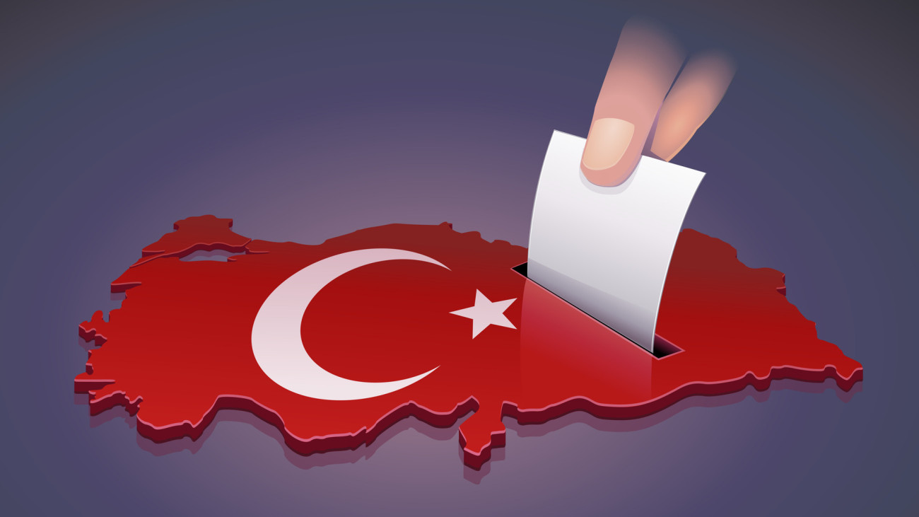 Hand dropping a ballot into a slot on the 3D map of Turkey in the colors of the Turkish flag symbolizing an election in Turkey on dark background