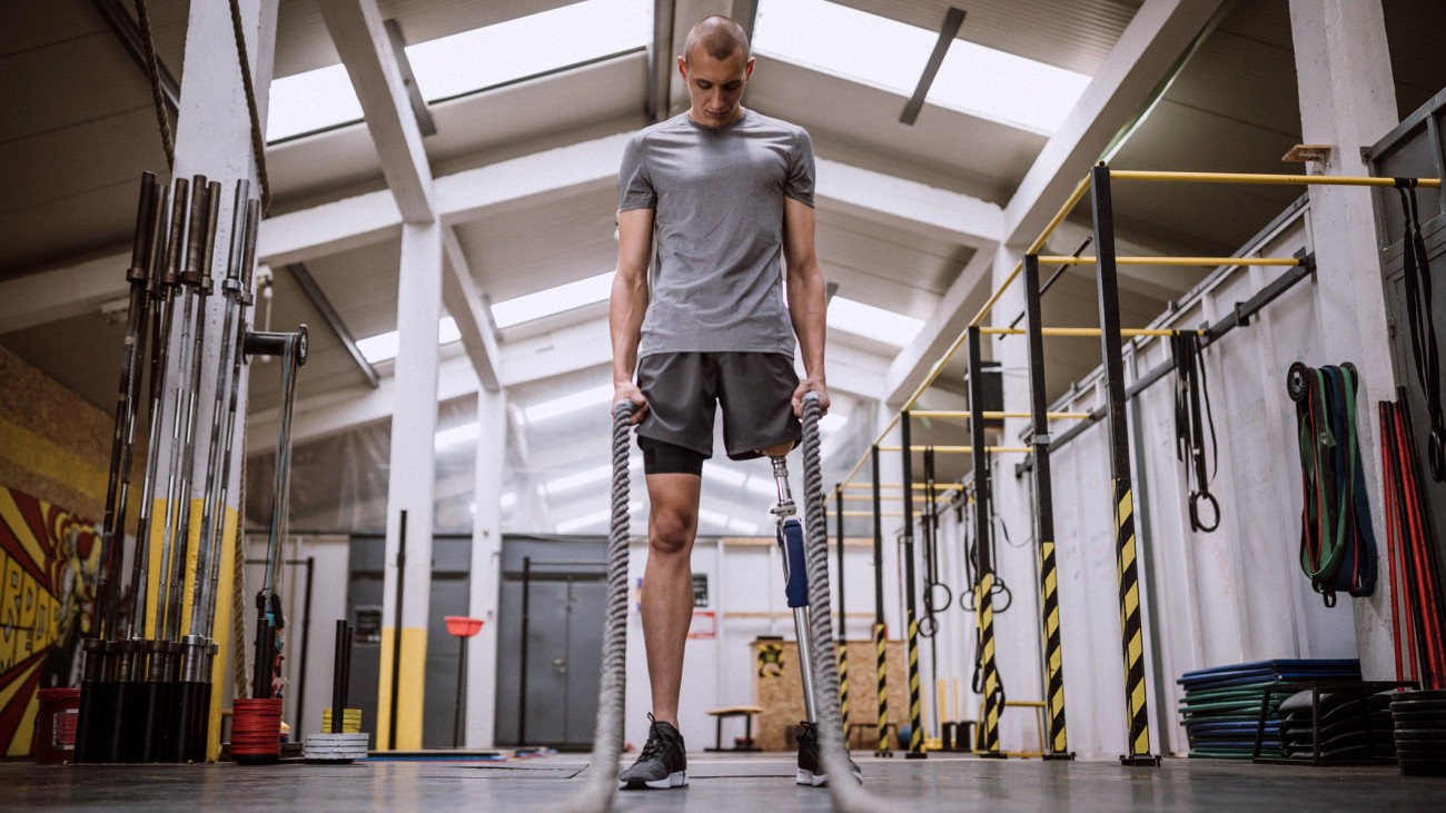Man With Amputee Leg Doing Battle Rope Exercises In Gym