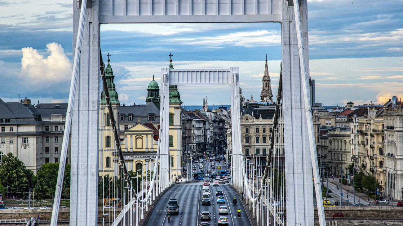 Budapest, 2022. július 30. Az Erzsébet híd a délutáni forgalom idején. Háttérben a Duna pesti oldalán lévő épületek, balra a Budapest-Belvárosi Nagyboldogasszony Főplébánia-templom. MTVA/Bizományosi: Róka László