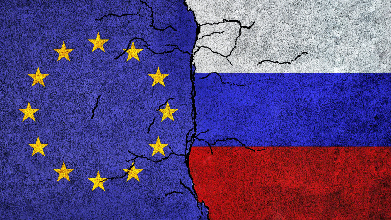 Russia and European Union painted flags on a wall with grunge texture. Russia vs EU