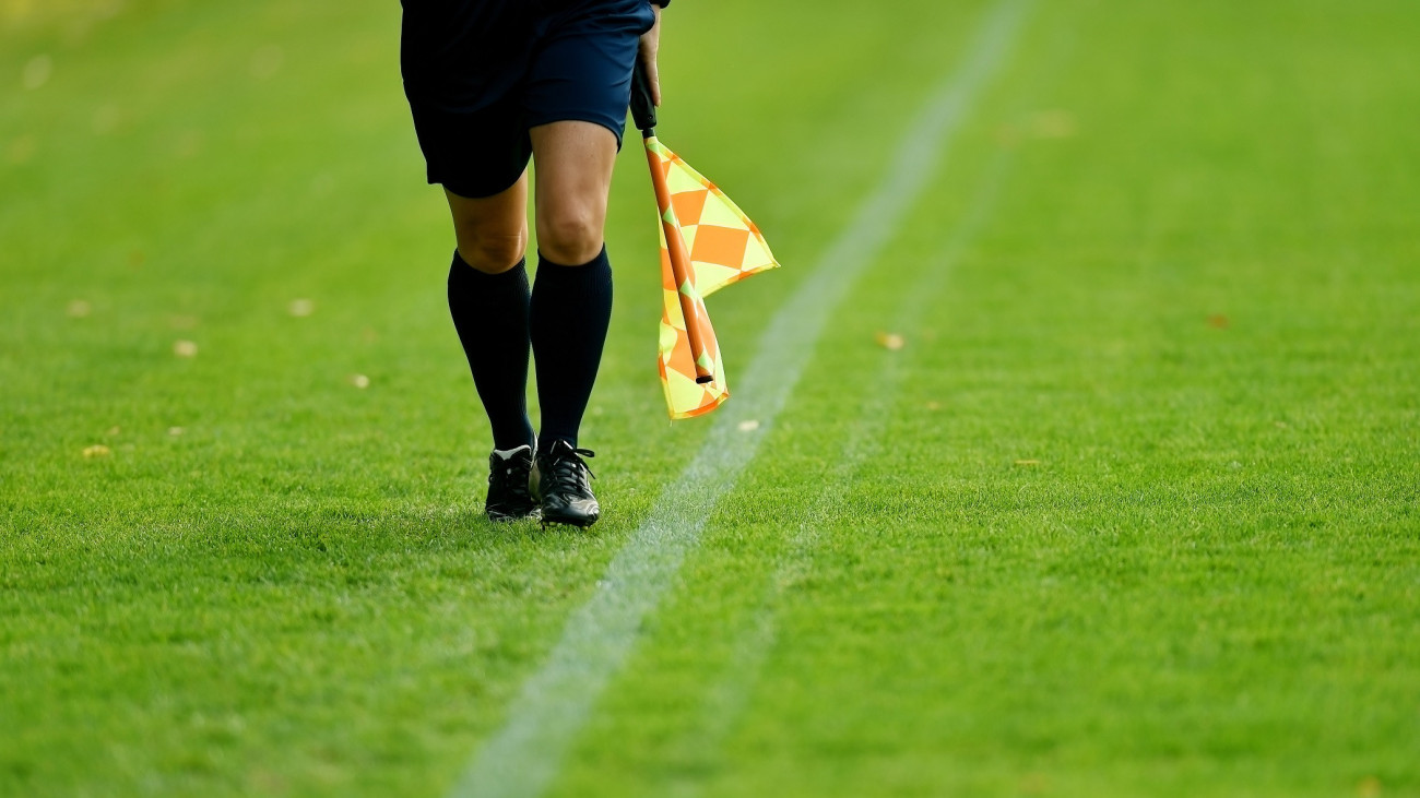 Assistant referee running along the sideline during a soccer match