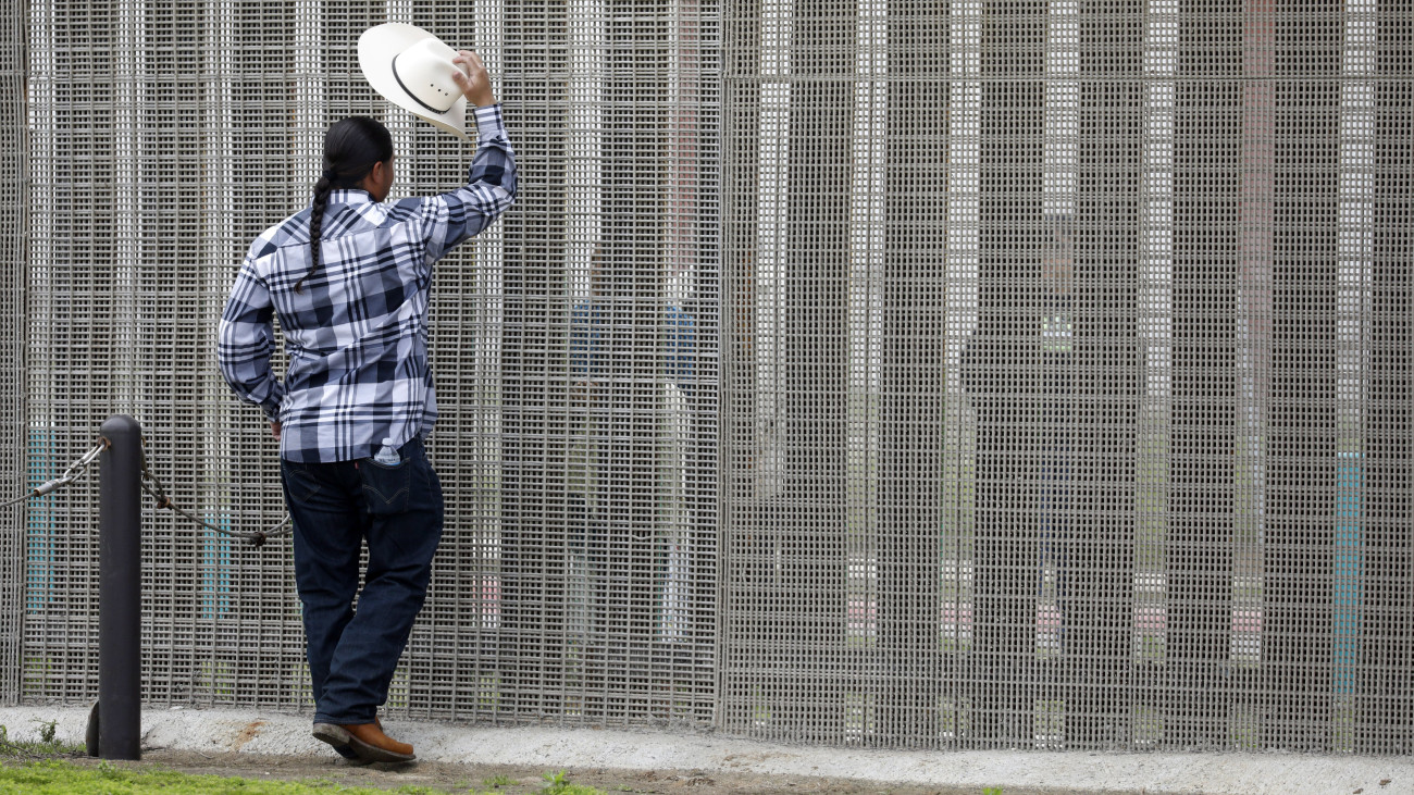 San Diego, 2017. március 27.Egy férfi az Egyesült Államokat és Mexikót elválasztó kerítés amerikai oldalán állva beszélget mexikói hozzátartozójával a Border Field Nemzeti Parkban, San Diegóban 2017. március 26-án. A mexikói Tijuanát és San Diegót elválasztó, fémoszlopokból álló, 5 méter magas fal a Csendes-óceántól a kaliforniai hegyekig tart több mint 20 kilométer hosszan. (MTI/EPA/Jason Szenes)