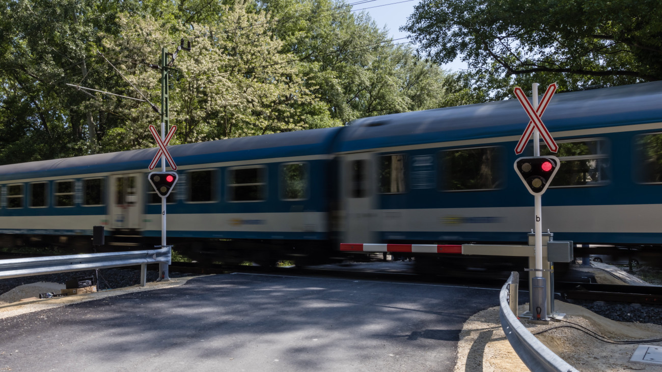 Vonat halad át az új, fény- és félsorompóval ellátott vasúti átjáróban Keszthelyen az átadás npján, 2023. május 26-án.