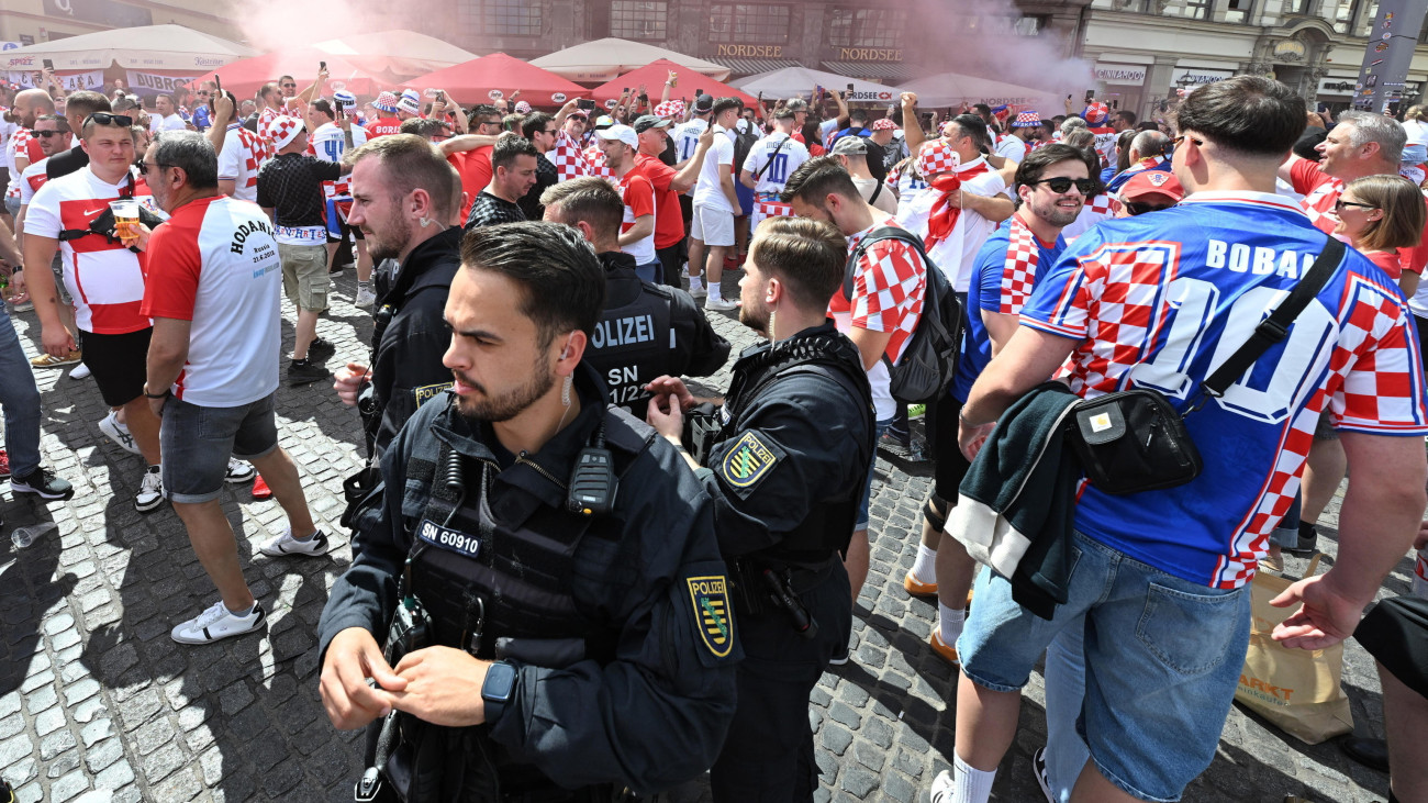 Rendőrök felügyelik a horvát szurkolókat a 2024-es németországi labdarúgó Európa-bajnokság B csoportja harmadik fordulójának Horvátország-Olaszország mérkőzése előtt Lipcsében 2024. június 24-én.