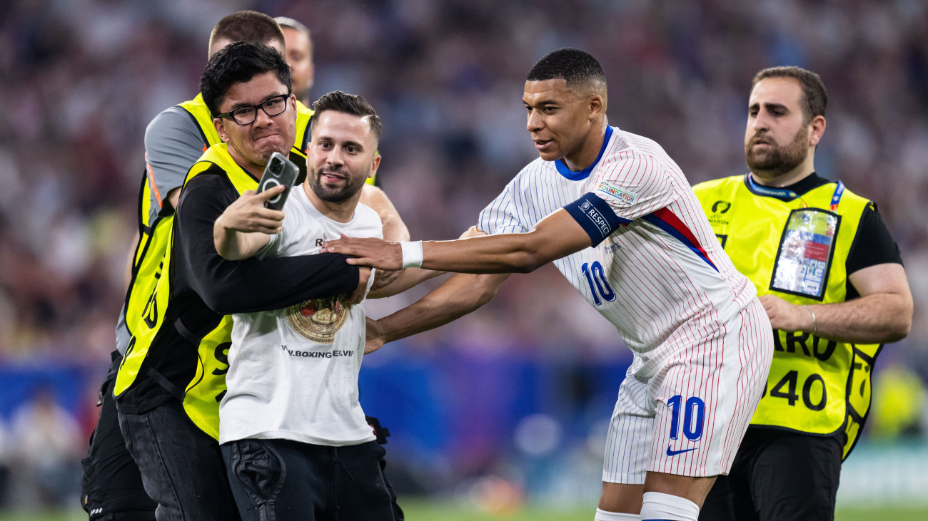 MUNICH, GERMANY - JULY 09: A pitch invador tries to take a photo with Kylian Mbappe of France during the UEFA EURO 2024 semi-final match between Spain v France at Munich Football Arena on July 09, 2024 in Munich, Germany. (Photo by Markus Gilliar - GES Sportfoto/Getty Images)