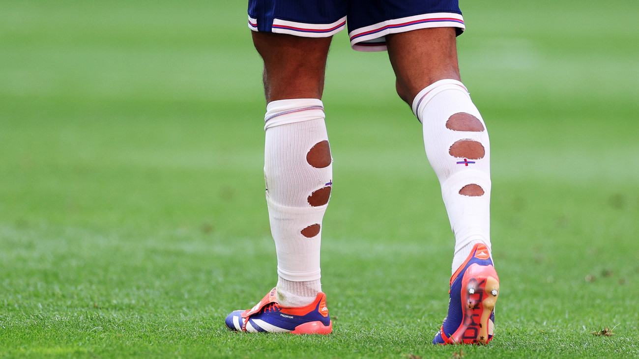 DUSSELDORF, GERMANY - JULY 06: A detailed view of the ripped socks and Adidas Predator football boots of Jude Bellingham of England (obscured) during the UEFA EURO 2024 quarter-final match between England and Switzerland at DĂźsseldorf Arena on July 06, 2024 in Dusseldorf, Germany. (Photo by Dean Mouhtaropoulos/Getty Images)