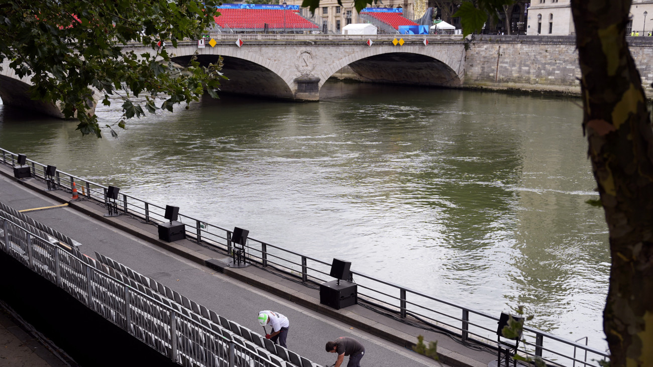 Széksorokat állítanak be munkások a Szajna partján Párizsban 2024. július 21-én, a párizsi olimpia megnyitóünnepsége előtt öt nappal. A folyó fővárosi szakaszán rendezik az ötkarikás játékok nyíltvízi úszását és a triatlonversenyek úszószámát.
