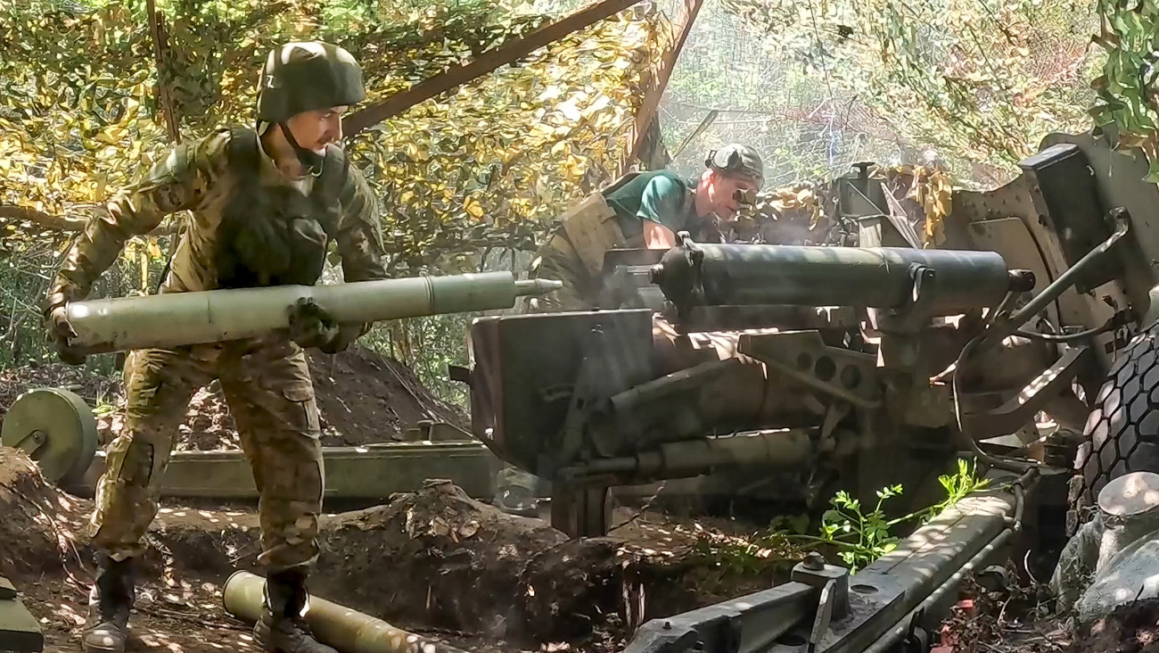 Az orosz védelmi minisztérium 2024. július 16-án közreadott videójáról készített képen orosz katonák 100 milliméteres Rapira páncéltörü ágyút töltenek meg lőszerrel Ukrajnában.