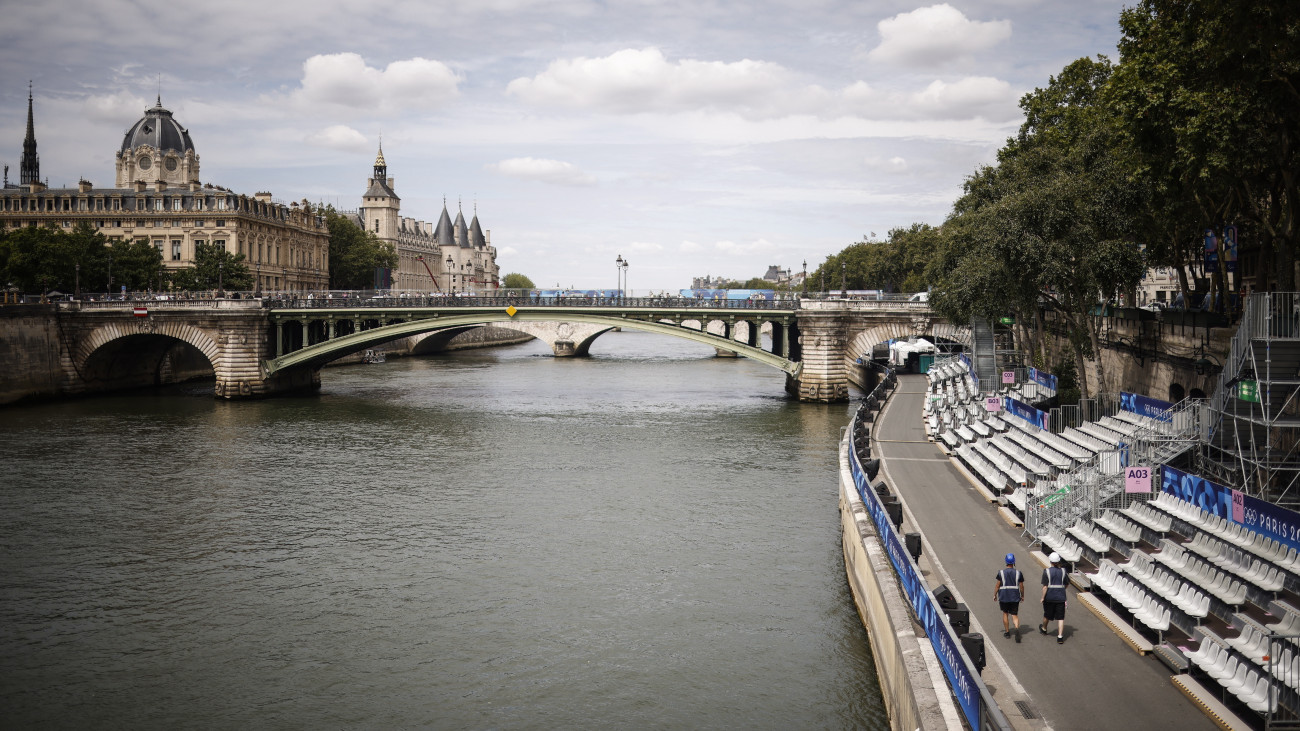 A Szajna partján felállított tribünök előtt az előkészületeket végző dolgozók Párizsban a párizsi nyári olimpia kezdete előtti napon, 2024. július 25-én.