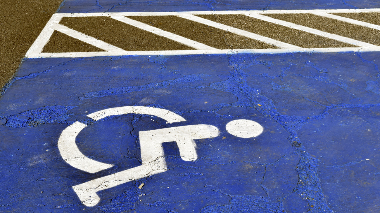 Mozgáskorlátozott jármű parkoló felfestések a Tesco, egy angliai székhelyű nemzetközi kiskereskedelmi áruházlánc Fogarasi úti parkolójában. A mozgássérült parkolót nem csak a mozgássérültek, de erre jogosító kártyával rendelkező egyéb fogyatékossággal élők is használhatják. A mozgássérült parkolótól a mozgássérülteknek az épület bejáratát a lehető legrövidebb akadálymentes útvonalon elérhetővé kell tenni. MTVA/Bizományosi: Branstetter Sándor  *************************** Kedves Felhasználó!